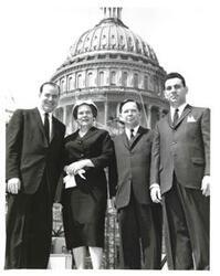 ["Black and white photograph of Carl Albert with two men and a woman."]