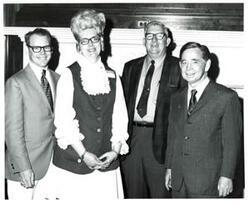 ["Black and white photograph of Carl Albert with two men and a woman."]