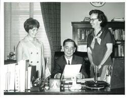 ["Black and white photograph of Carl Albert with two women."]