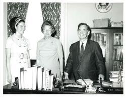 ["Black and white photograph of Carl Albert with two women."]