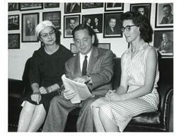 ["Black and white photograph of Carl Albert with two women."]