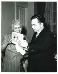 ["Black and white photograph of Carl Albert with a woman looking the book, \"Up From Slavery.\""]