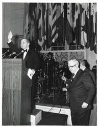 ["Black and white photograph of Carl Albert standing at a podium at the American Revolution Bicentennial Ball in Oklahoma. October 2, 1976. Tom Steed is also present."]