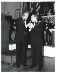 ["Black and white photograph of Carl Albert with a man (possibly the master of ceremonies) at the American Revolution Bicentennial Ball in Oklahoma. October 2, 1976"]