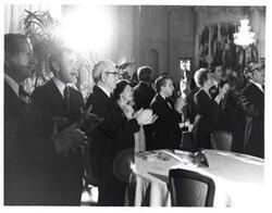 ["Black and white photograph of Dewey F. Bartlett, Carl Albert and Mary Albert, and Tom Steed are shown in a crowd of people apparently rendering a standing ovation to some performer or speaker at the American Revolution Bicentennial Ball in Oklahoma. October 2, 1976"]