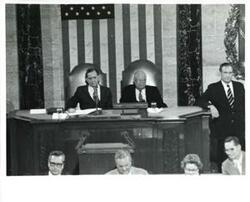 ["Black and white photograph of  Gerald R. Ford speaking at a joint session of Congress. Carl Albert and James O. Eastland also shown. October 8, 1974"]