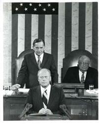 ["Black and white photograph of  Gerald R. Ford speaking at a joint session of Congress. Carl Albert and James O. Eastland also shown. October 8, 1974"]