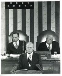 ["Black and white photograph of  Gerald R. Ford speaking at a joint session of Congress. Carl Albert and James O. Eastland also shown. October 8, 1974"]