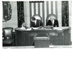 ["Black and white photograph of  Gerald R. Ford speaking at a joint session of Congress. Carl Albert and James O. Eastland also shown. October 8, 1974"]
