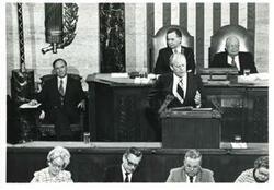 ["Black and white photograph of  Gerald R. Ford speaking at a joint session of Congress. Carl Albert and James O. Eastland also shown. October 8, 1974"]