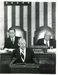 ["Black and white photograph of  Gerald R. Ford speaking at a joint session of Congress. Carl Albert and James O. Eastland also shown. October 8, 1974"]