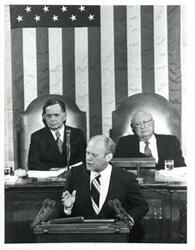 ["Black and white photograph of  Gerald R. Ford speaking at a joint session of Congress. Carl Albert and James O. Eastland also shown. October 8, 1974"]