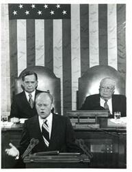 ["Black and white photograph of  Gerald R. Ford speaking at a joint session of Congress. Carl Albert and James O. Eastland also shown. October 8, 1974"]