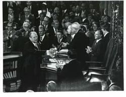 ["Black and white photograph of  Gerald R. Ford speaking at a joint session of Congress. Carl Albert and James O. Eastland also shown. October 8, 1974"]