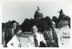 ["Black and white photograph print of Carl Albert and Mary Albert standing outside with two other men. House delegation trip. August 1975"]