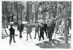 ["Black and white photograph print of Carl Albert, Leonid Brezhnev, and other men walking outside in Yalta."]