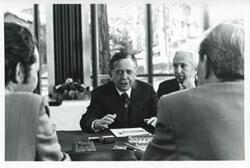 ["Black and white photograph print of Carl Albert seated at a conference table with other men. House delegation trip. August 1975"]