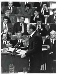 ["Gerald R. Ford's State of the Union message. Carl Albert and Nelson A. Rockefeller are seated behind Ford."]