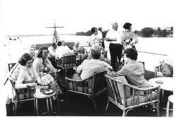 ["Mary Albert, Betty Ford, Happy Rockefeller, and Thomas P. O'Neill. in foreground. Gerald R. Ford and Mike Mansfield in background. Are shown with a group of other guests aboard the Sequoia. July 22, 1975"]