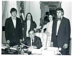["Four young adults with Carl Albert in his office."]