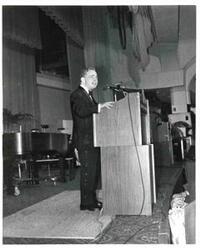 ["Carl Albert standing behind a podium."]