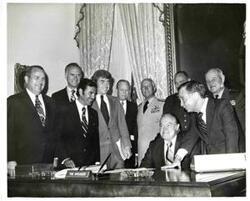 ["Carl Albert with Bob Hope. Several military officers and congressmen, including Jack Kemp, are in background."]