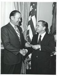 ["Carl Albert shaking hands with a man."]