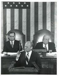 ["Gerald R. Ford giving his State of the Union message. Carl Albert is seated behind him to the left and James O. Eastland is behind to the right."]