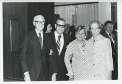 ["Black and white photograph print of a group of people at an unidentified function."]