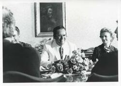 ["Black and white photograph print of President Josip B. Tito and others seated at a dinner table."]
