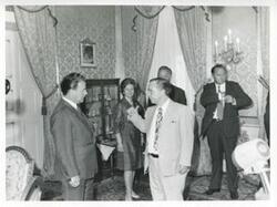 ["Black and white photograph print of Carl Albert speaking with unidentified people."]