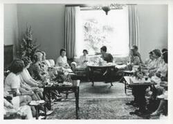 ["Black and white photograph print of Mary Albert seated on a couch with other women. House delegation trip. August 1975"]