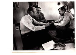 ["The image depicts Dewey Bartlett seated in an airplane with Gerald Ford, Henry Bellmon and another man"]
