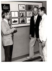 ["The image depicts Harry Reynolds (Associate Director of Lawrence Livermore Laboratory), Duane C. Sewell (Assistant Secretary for Defense Programs, Department of Energy), and Dewey Bartlett at the Lawrence Livermore Laboratory"]