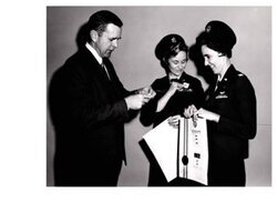["The image depicts Dewey Bartlett standing with two Air Force Officers, Lieutenant Astafan and Lieutenant Fletcher"]