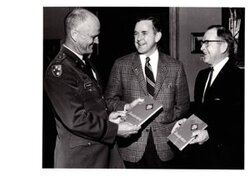 ["The image depicts Dewey Bartlett standing with Colonel Jack L. Treadwell and Colonel Roy P. Stewart"]
