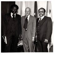 ["The image depicts Dewey Bartlett standing with Dan Palmer and Walter Block in his office"]