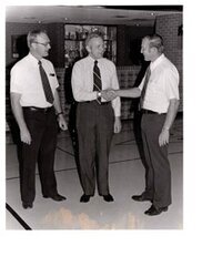 ["The image depicts Dewey Bartlett at the Medford Public School shaking hands with Ray Innis and Clen Campbell"]