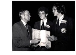 ["The image depicts Dewey Bartlett standing with Kevin Vaughn and Vernon Cowdry at the National Youth Science Camp"]