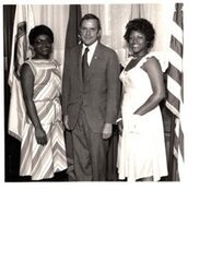["The image depicts Dewey Bartlett standing between Margie Barre and Paula Barre of the Tulsa Urban League"]