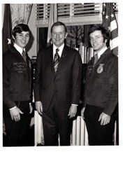 ["The image depicts Dewey Bartlett standing between Bart Brashears and Alpha Trinelle, two national officers for the FFA"]