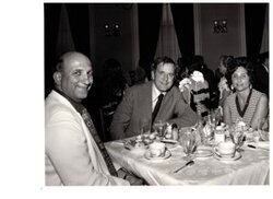 ["The image depicts Dewey Bartlett seated at a dinner table with Rube and Shari Reingold of Henryetta, Oklahoma"]