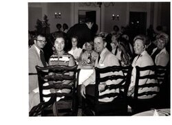 ["The image depicts Dewey Bartlett seated with Mrs. Smith and Mrs. Feizel (POW wives), and their families"]