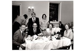 ["The image depicts Dewey Bartlett seated with Lew Ward and his family, and Ann Bartlett"]