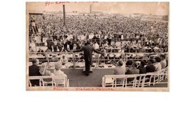 ["The image depicts Dewey Bartlett seated with many others, behind Richard Nixon who is speaking to a large Oklahoma crowd"]