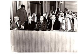 ["The image depicts Dewey Bartlett seated at the Federal National Assembly with Nather Omari, Clifford Hansen, Najmuddine Hamoodah, members of the Assembly with charge P. J. Griffen at the back and W. N. Howell, Jr. walking to the back"]
