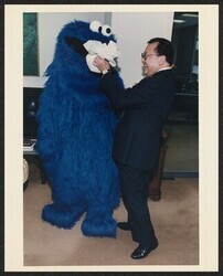 ["Caption: Hawaii Sen. Daniel Inouye feeds Sesame Street's Cookie Monster a bag of cookies during a Capitol Hill visit Tuesday promoting an exhibit on public television to open Monday in the Rayburn House Office Building in Washington, D.C."]