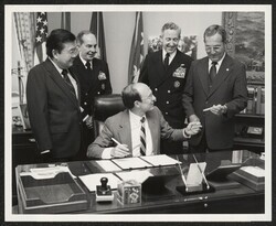 ["Caption: Acting Secretary of the Navy R. James Woolsey presents Mr. Harold B. Estes of Honolulu, with a pen used in signing the documents transferring the former USS BOWFIN (SS 287) to the Pacific Fleet Submarine Memorial Association on August 1st. Observ"]