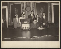 ["On label: Official. Agency for International Development signing. Stamp: USAID photo by Clyde McNair"]