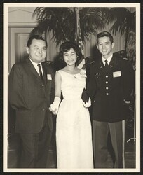 ["Caption: January 1965. Senator Daniel K. Inouye (D) State of Hawaii is warmly greeted and admired by kamaainas from the islands is shown with 1st Lt (Dr.) and Mrs. Andrew Chang, Medical Officer stationed at Ft Myers, North Post, Arlington, Va at the Congr"]